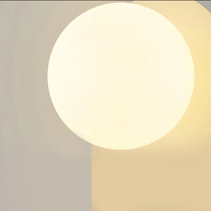 Lampe murale en forme de boule de verre sur une plaque