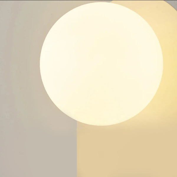 Lampe murale en forme de boule de verre sur une plaque